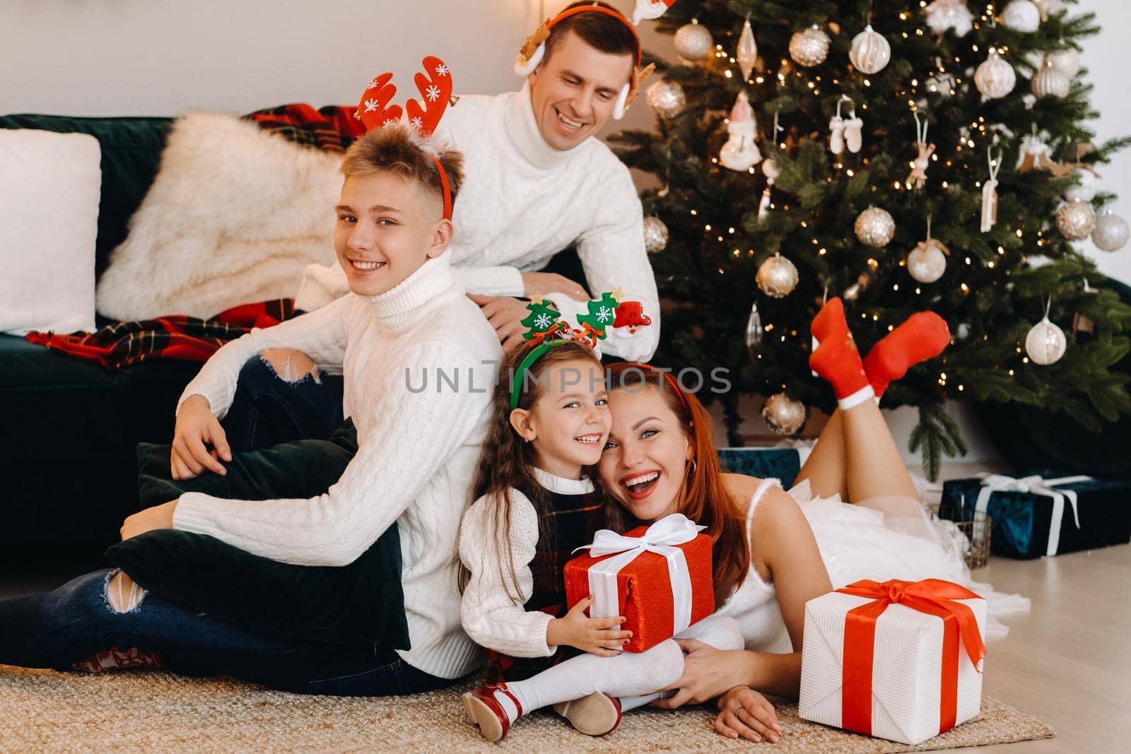 Happy family near the Christmas tree with gifts.