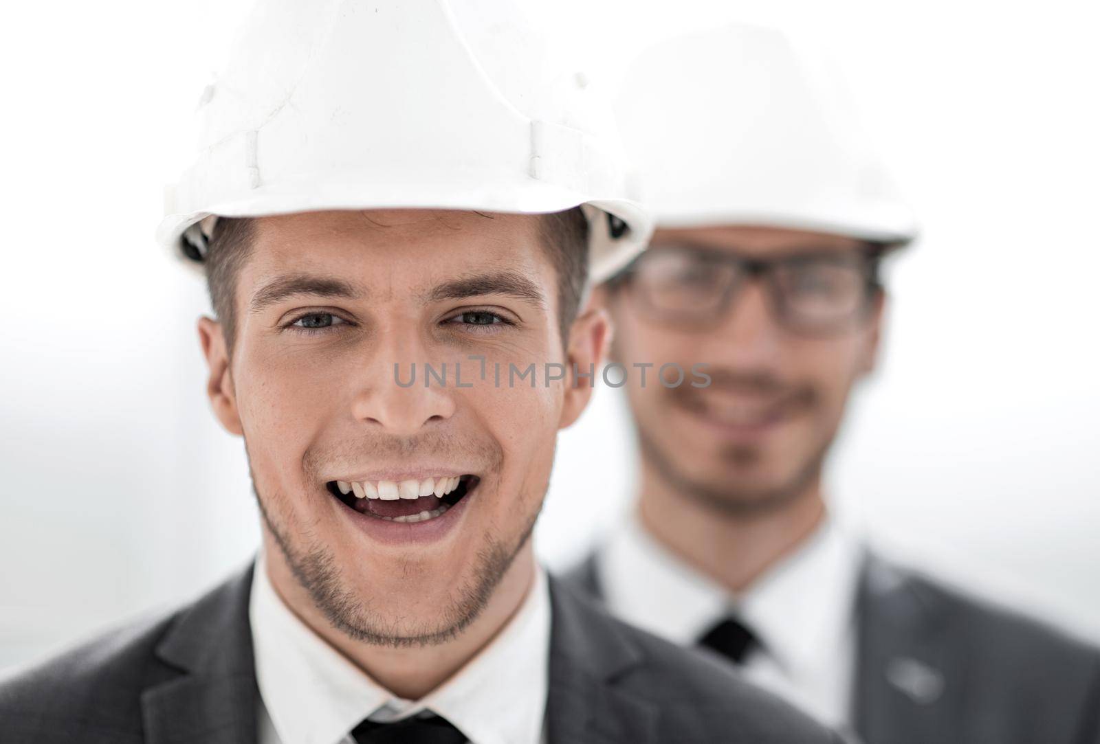 two engineers are looking into the camera and smiling. concept of construction. a large plan