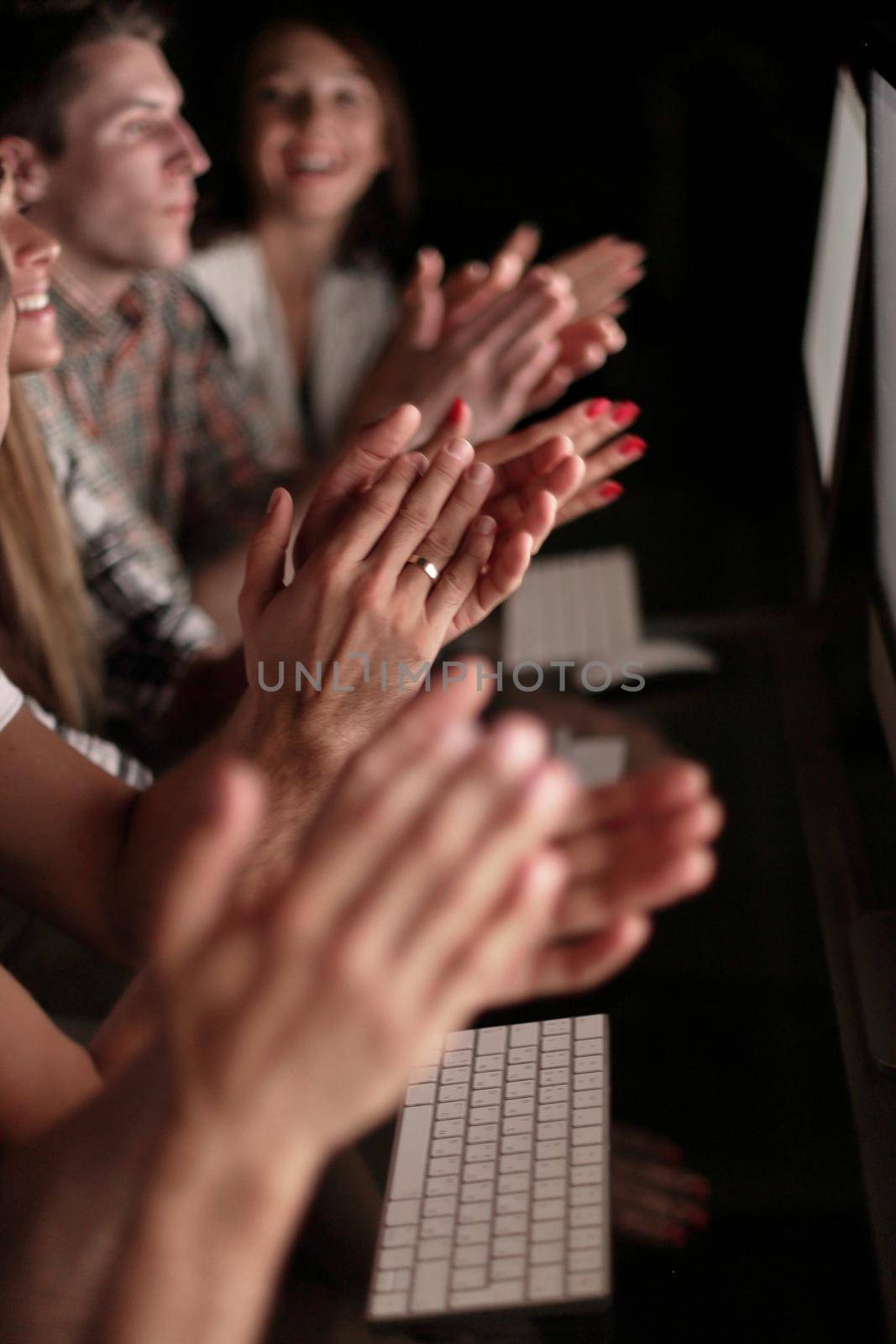 business team applauding while sitting in front of computer screens .success concept