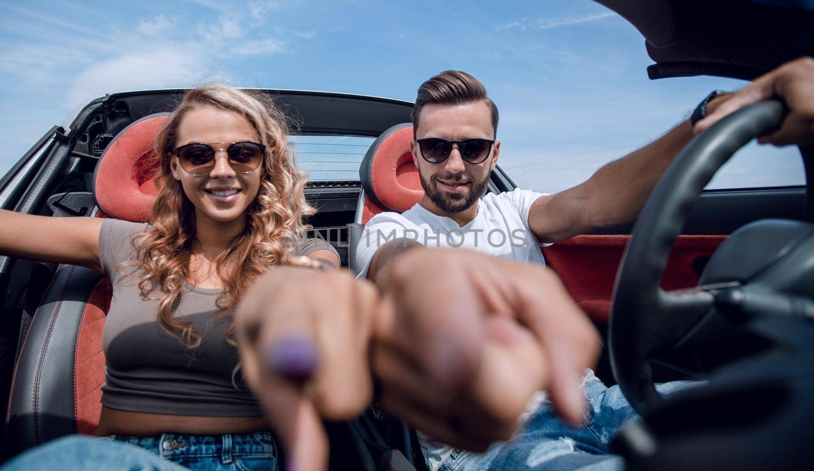 close up.happy couple sitting in the car and pointing at you. by asdf