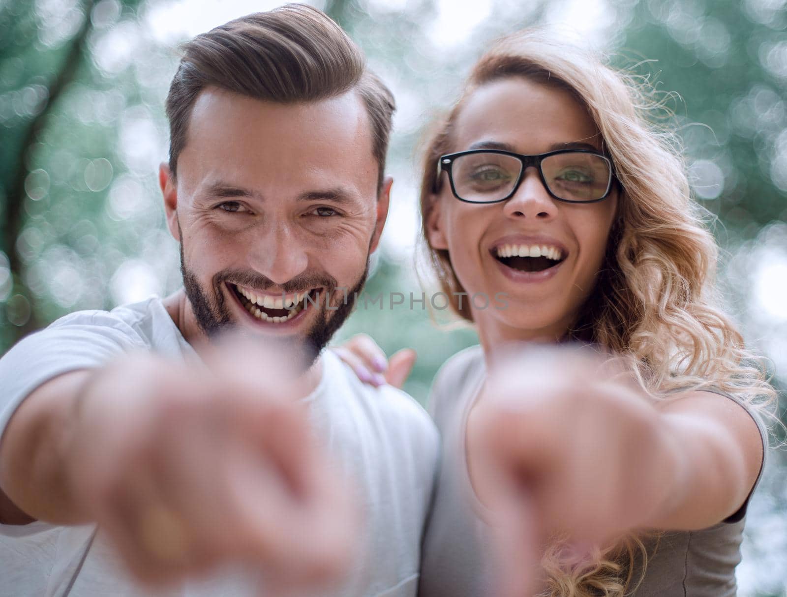 smiling young couple pointing at you by asdf