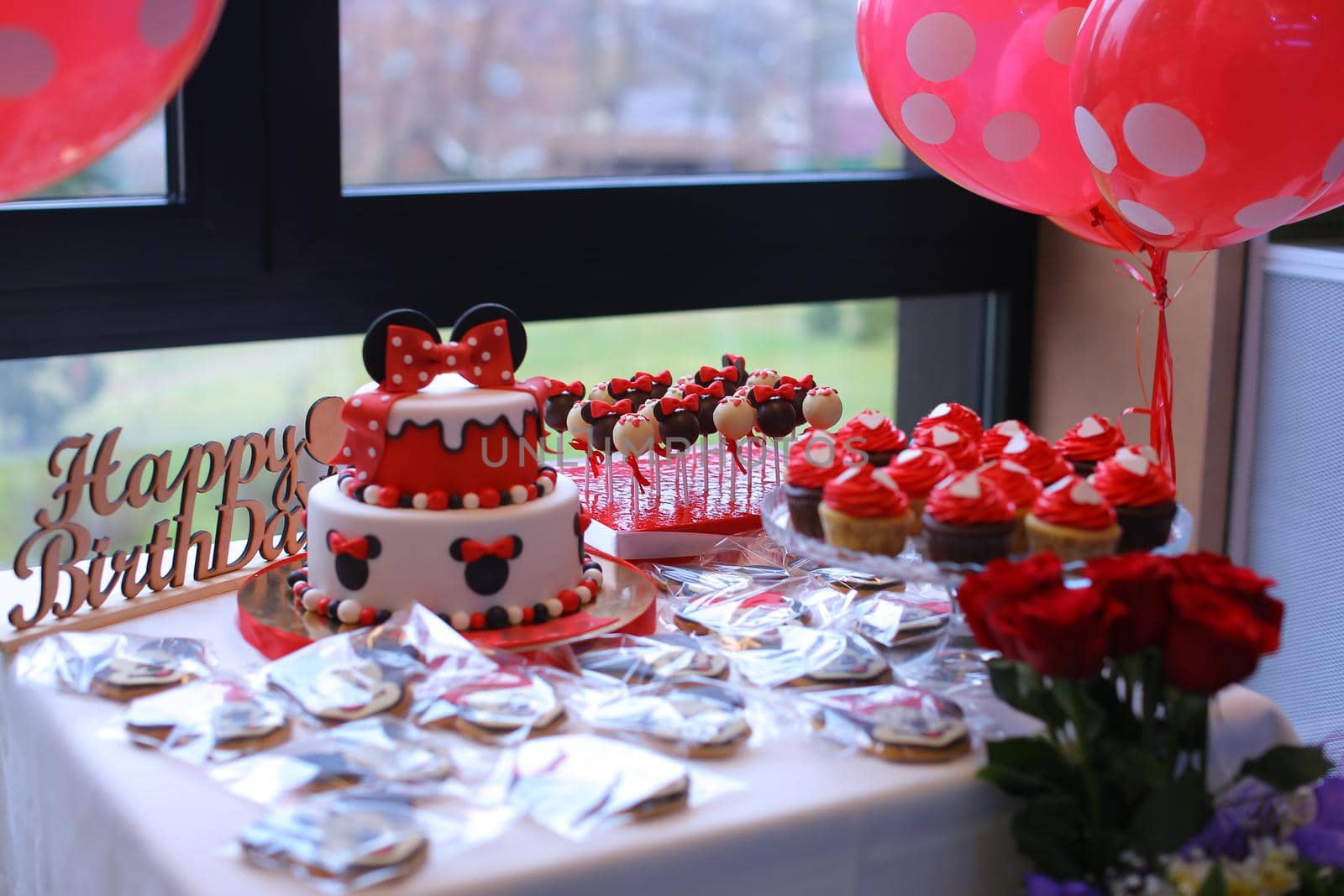 Red sweets and cake for birthday party. Concept of served and decorated table for calabration.