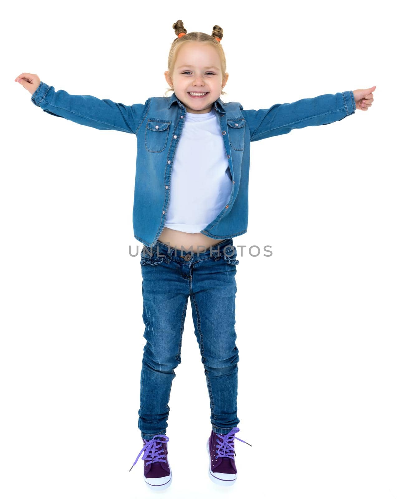 A little girl is jumping and waving her hands. The concept of a happy childhood, outdoor recreation. Isolated on white background.