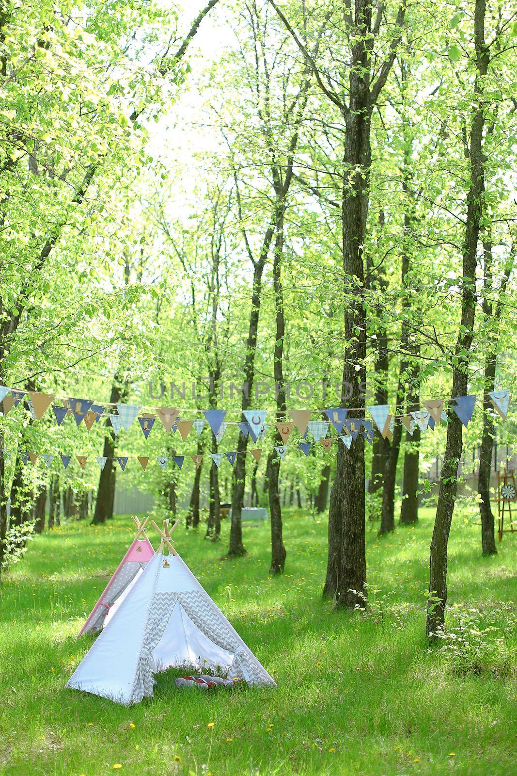 Blue handmade tent in forest, shiny weather. Concept of nature and summer vacations.