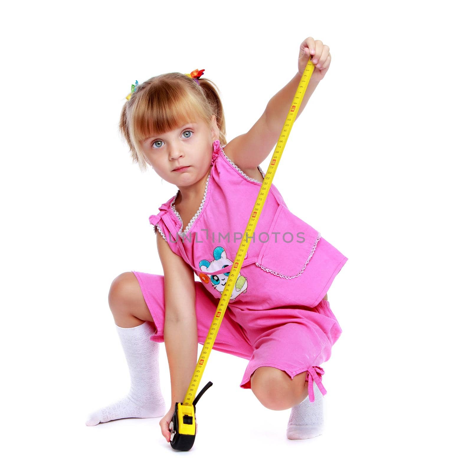 Cute little girl playing with a building tape. The concept of construction, advertising. Isolated on white background.