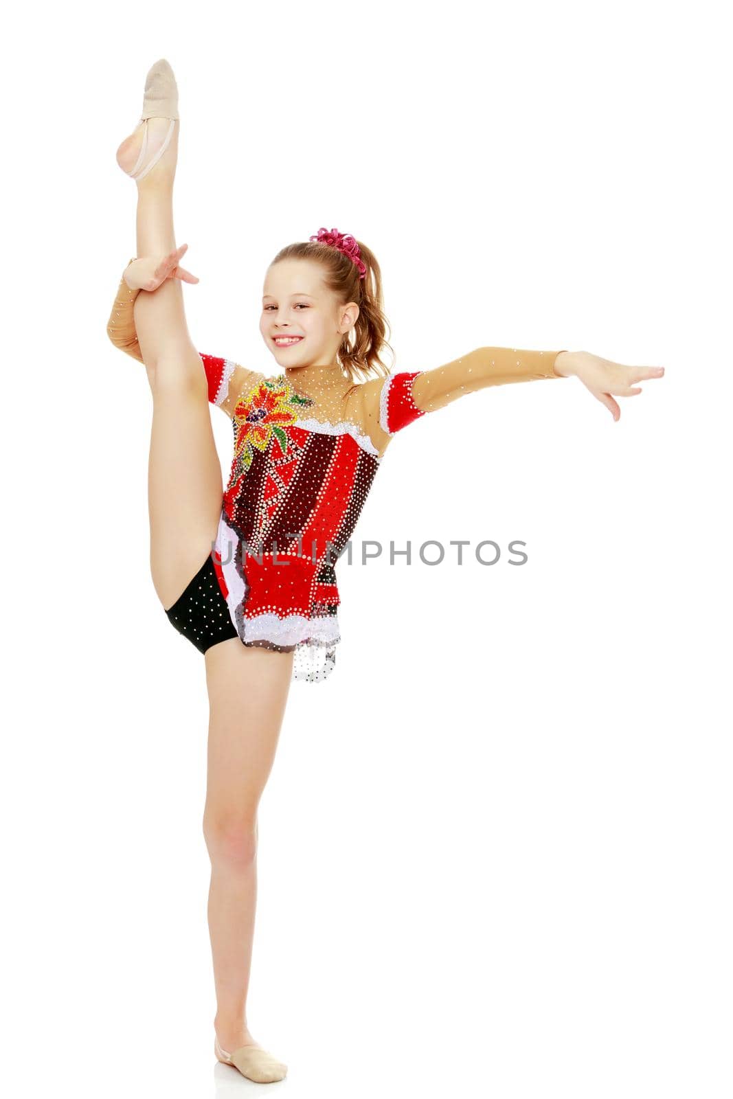 A girl gymnast balances on one leg.The concept of childhood, sport, a healthy lifestyle. Isolated on white background.