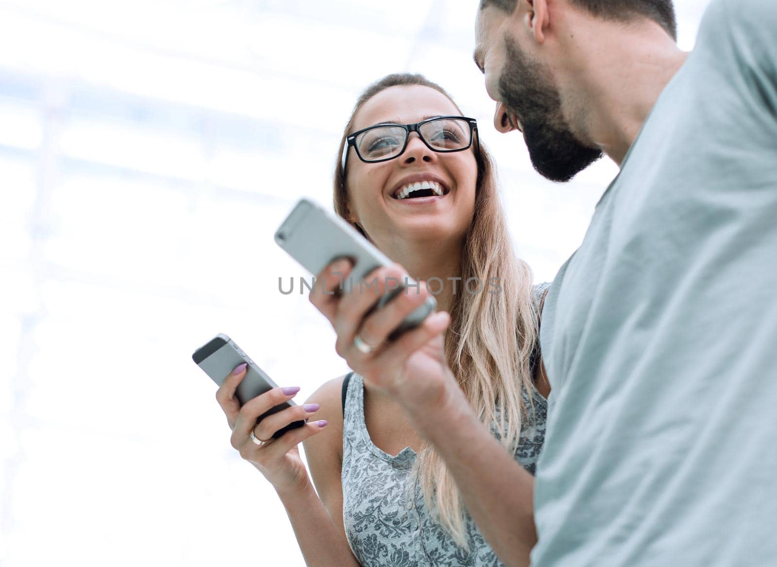 happy young couple with smartphones discussing video files .people and technology