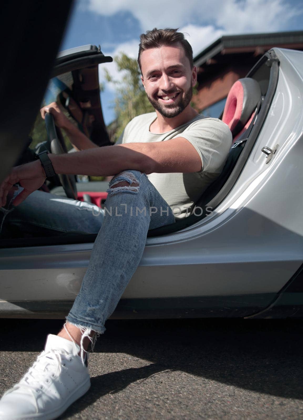 close up.handsome young man sitting in convertible ca by asdf