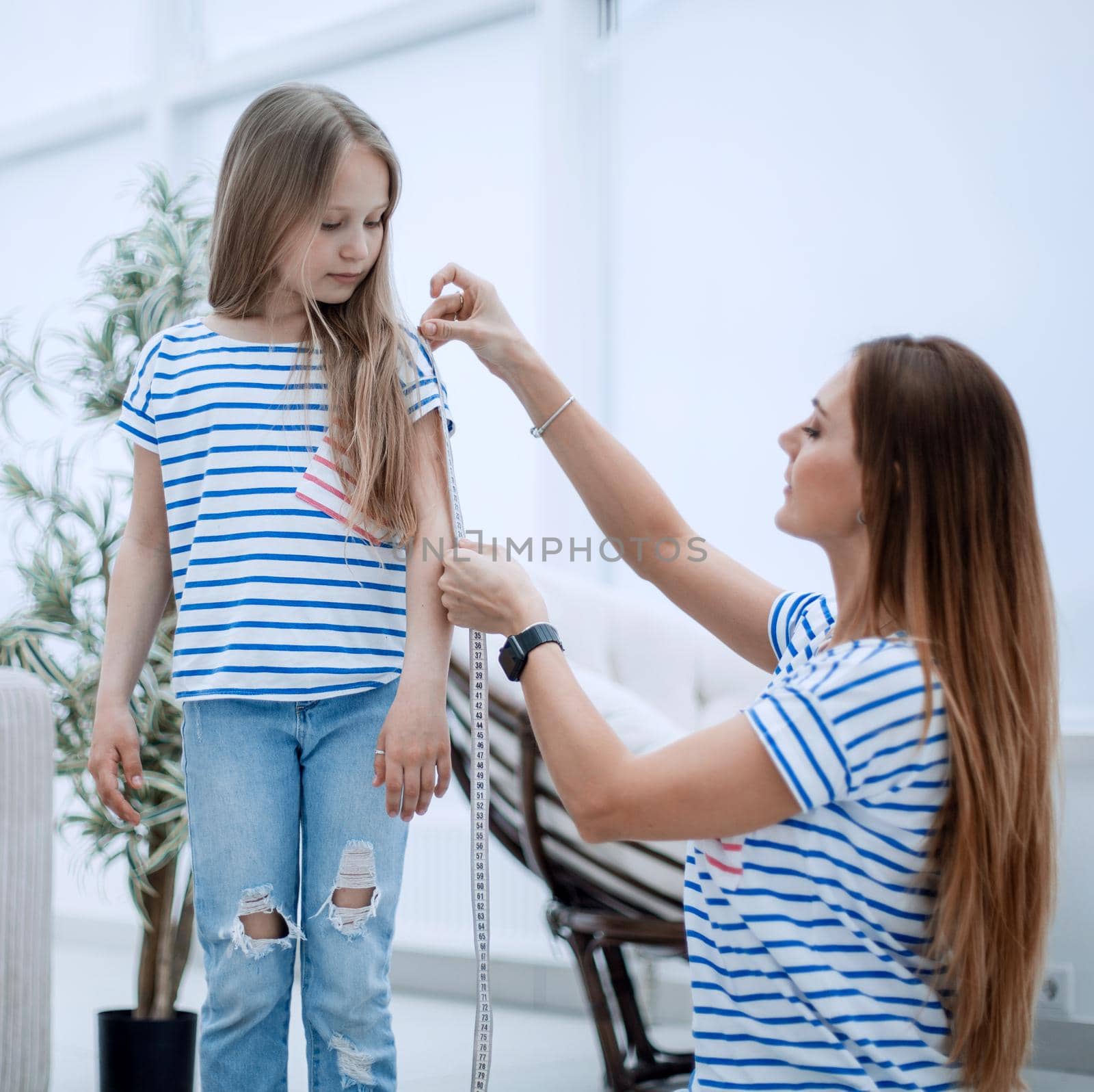 attentive mother and daughter make measurements for new clothes by asdf