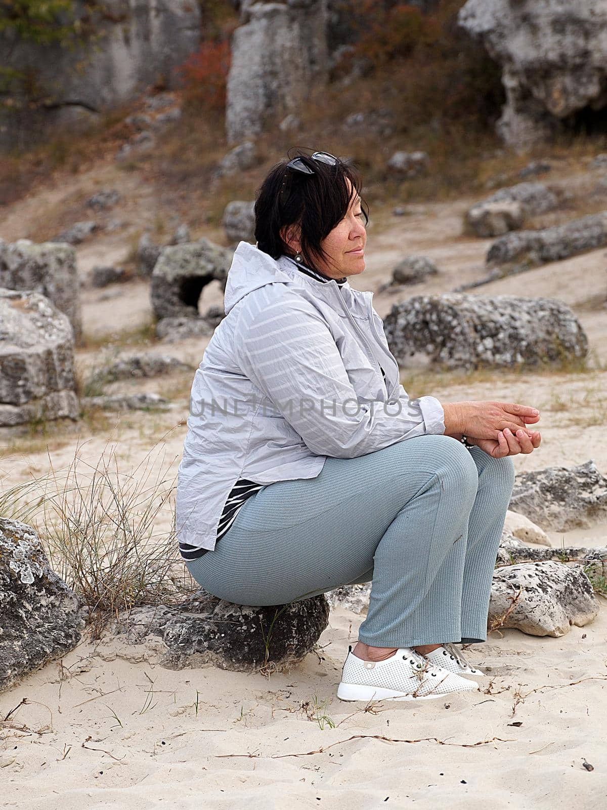 portrait of asian woman sitting on stone.