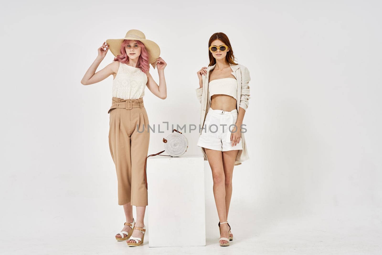 two girlfriends standing side by side posing fashion luxury. High quality photo