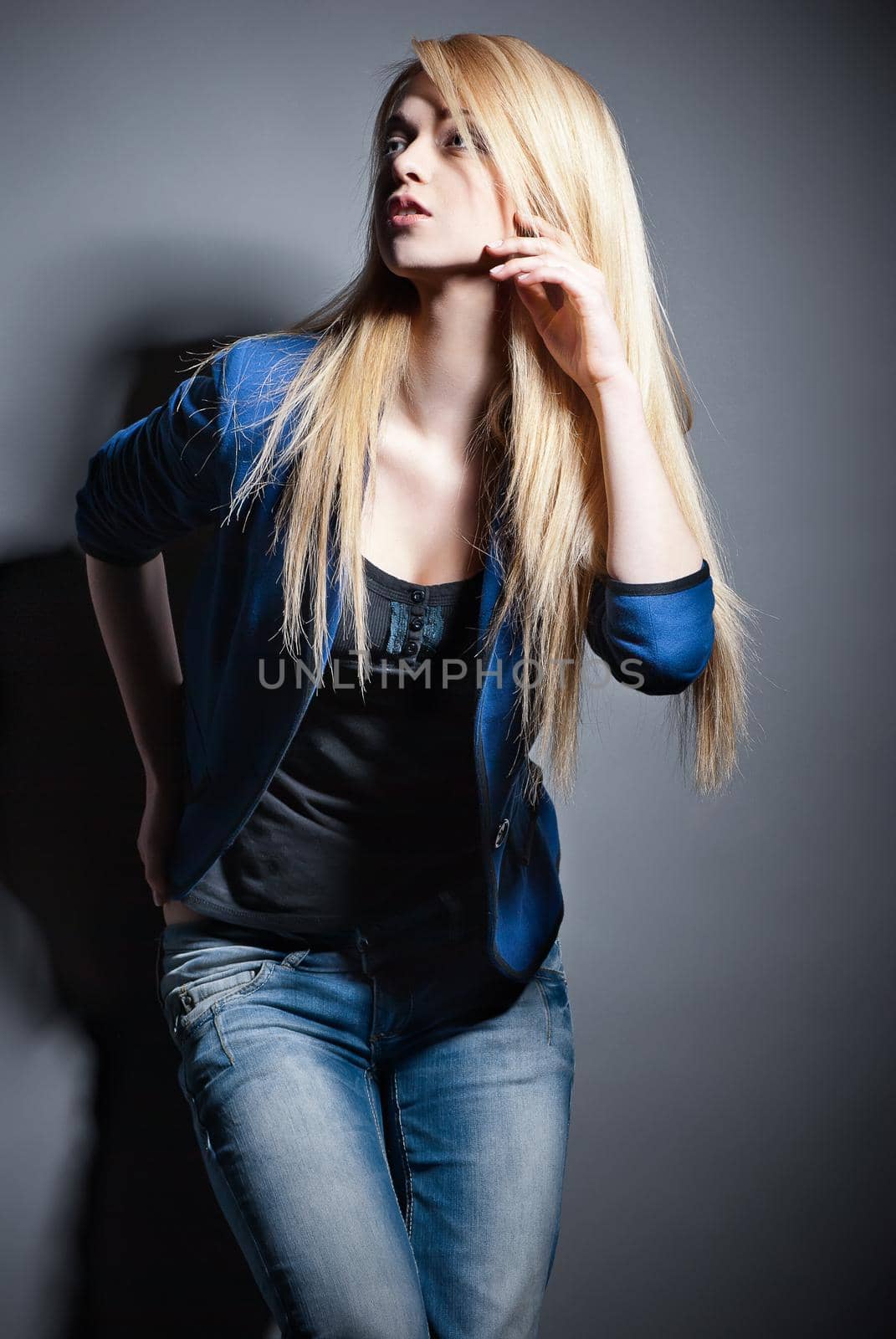 Portrait of beautyful oising blond woman with long straight hair on grey background