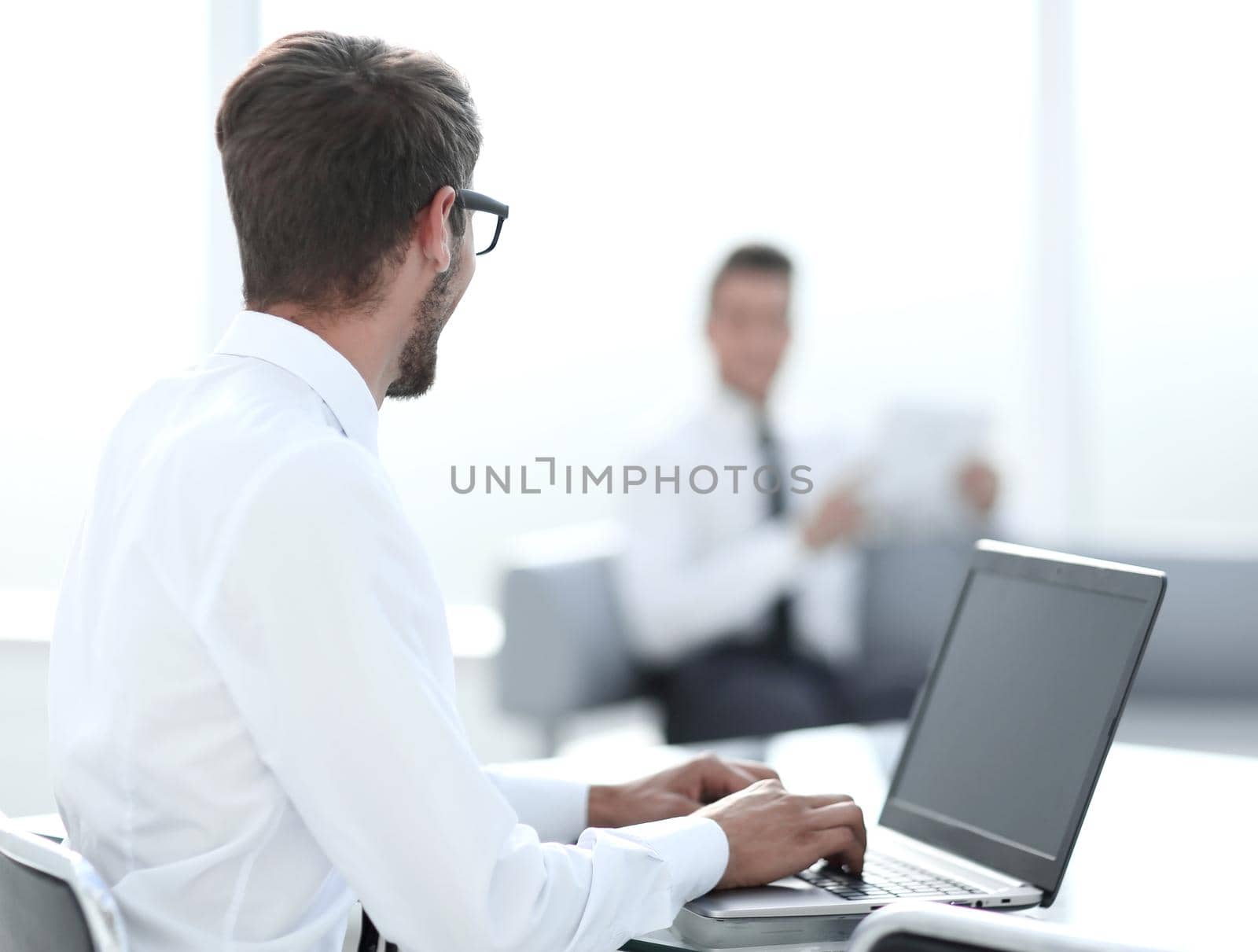 Young businessman in formalwear typing on laptop by asdf
