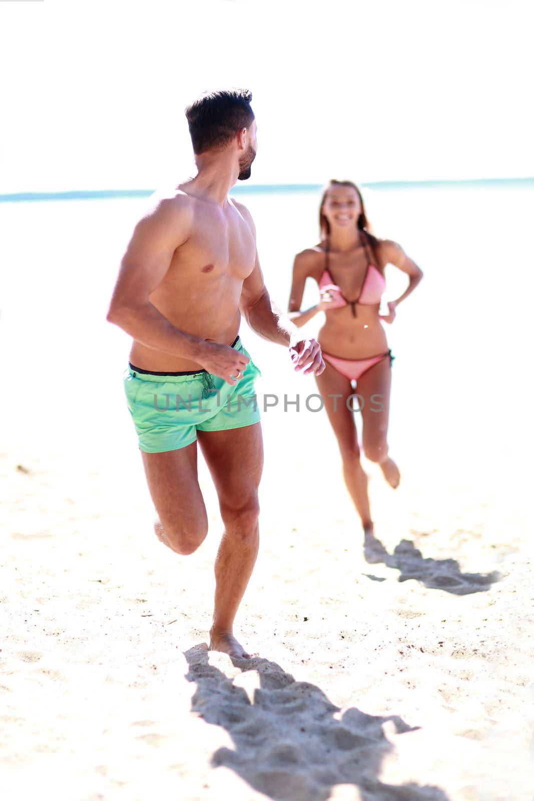 Happy couple having fun on the beach. by asdf