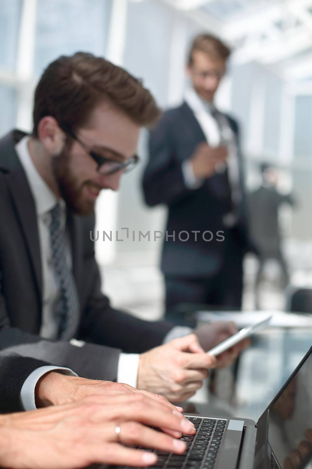 close up.business team using gadgets in a modern office by asdf