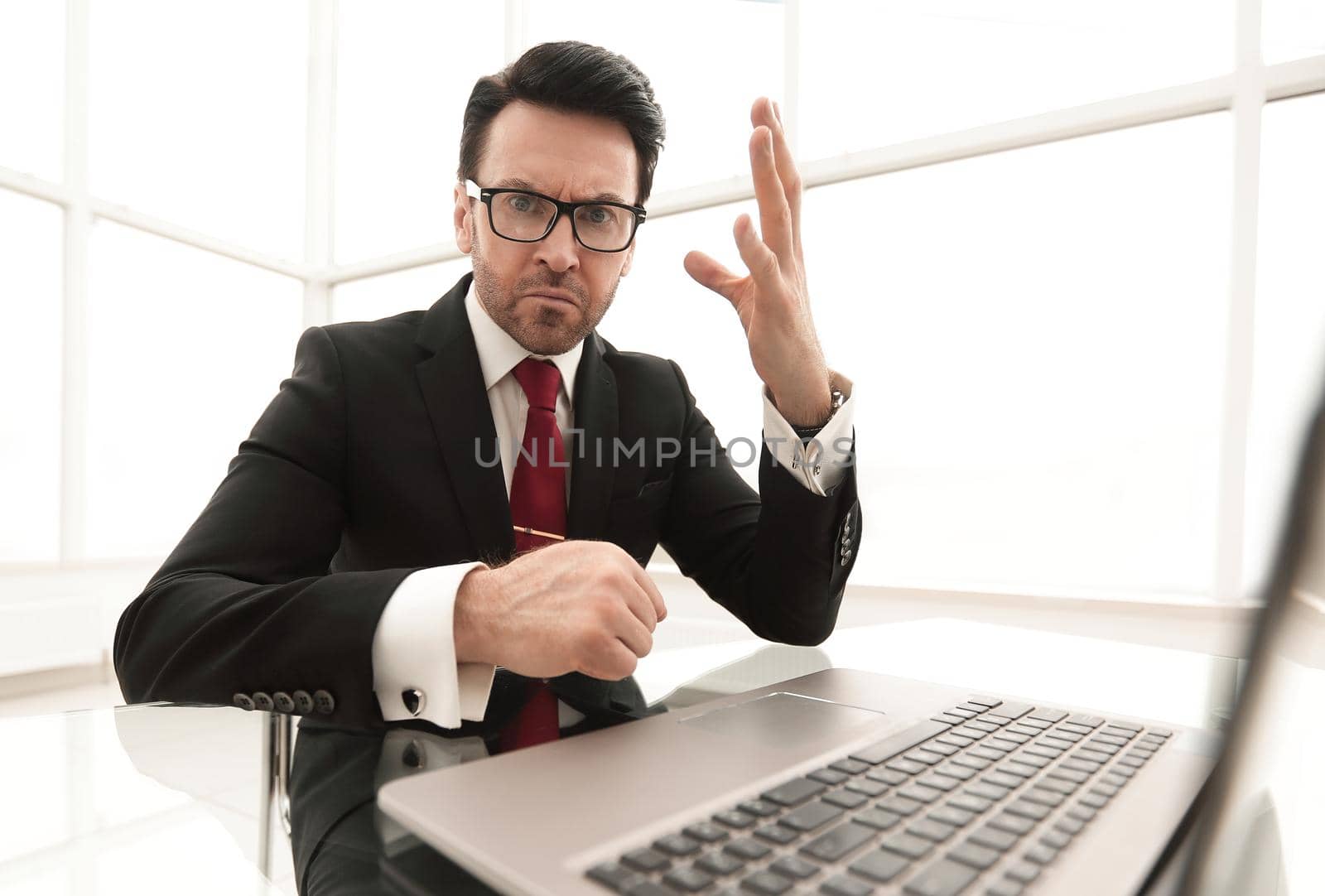 close up.serious businessman checking accounts while sitting at his Desk.business concept