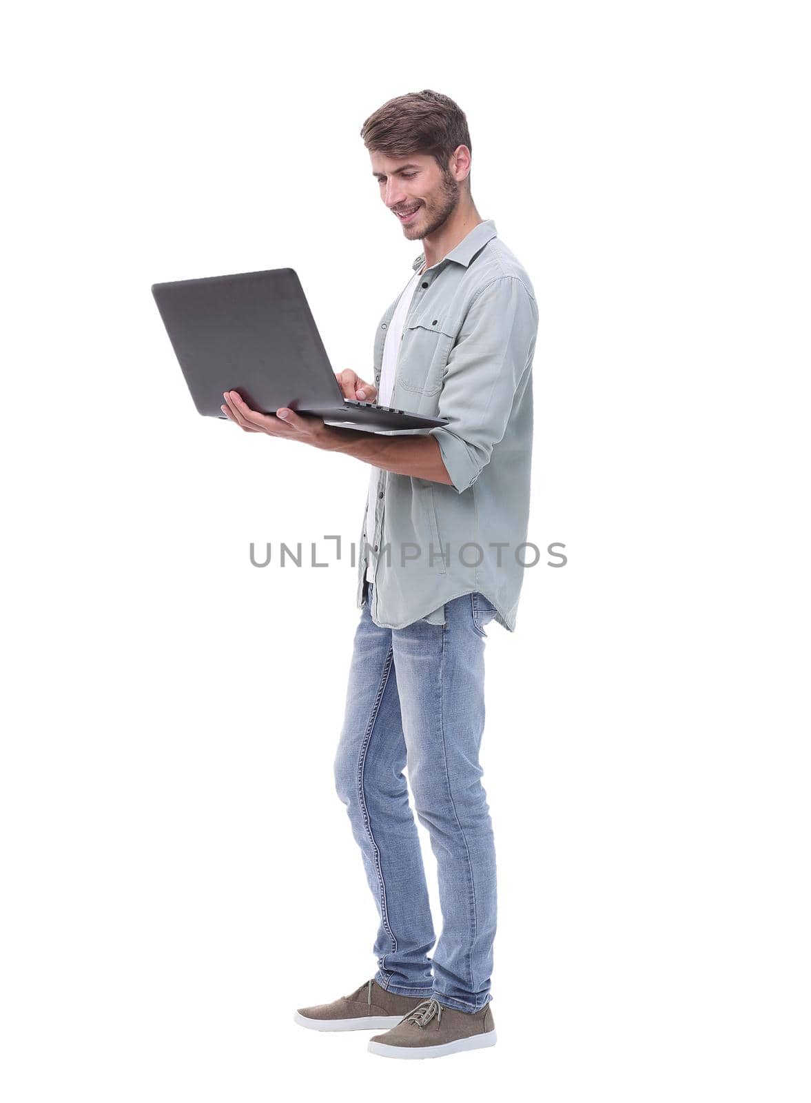 in full growth.smiling young man with laptop .isolated on white background