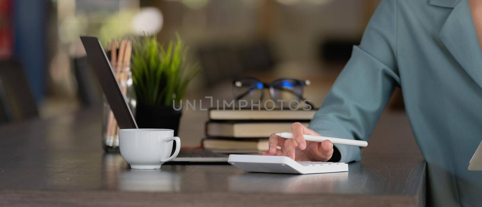 Close up businesswoman using calculator for analysis maketing plan, Accountant calculate financial report, computer with graph chart. Business, Finance and Accounting concepts.