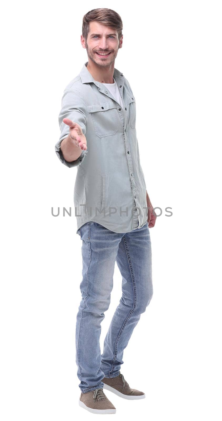 in full growth.young man holding out his hand for a handshake.isolated on white background