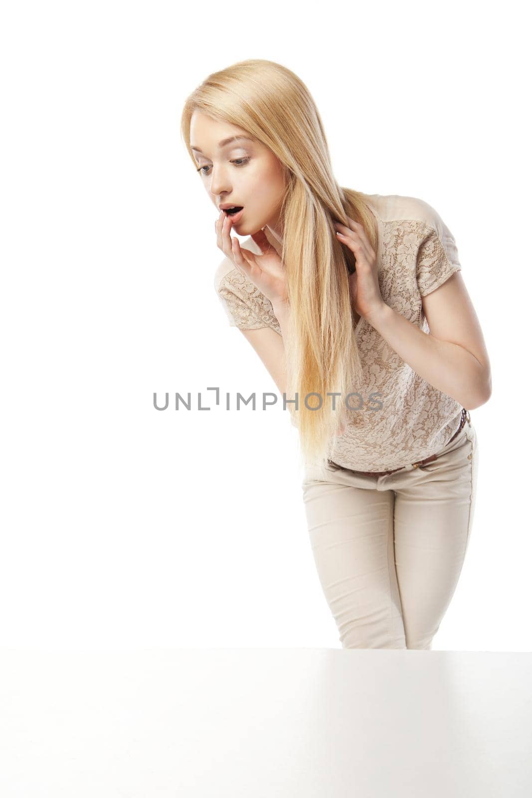 Young excited woman looking at the shop window isolated over white