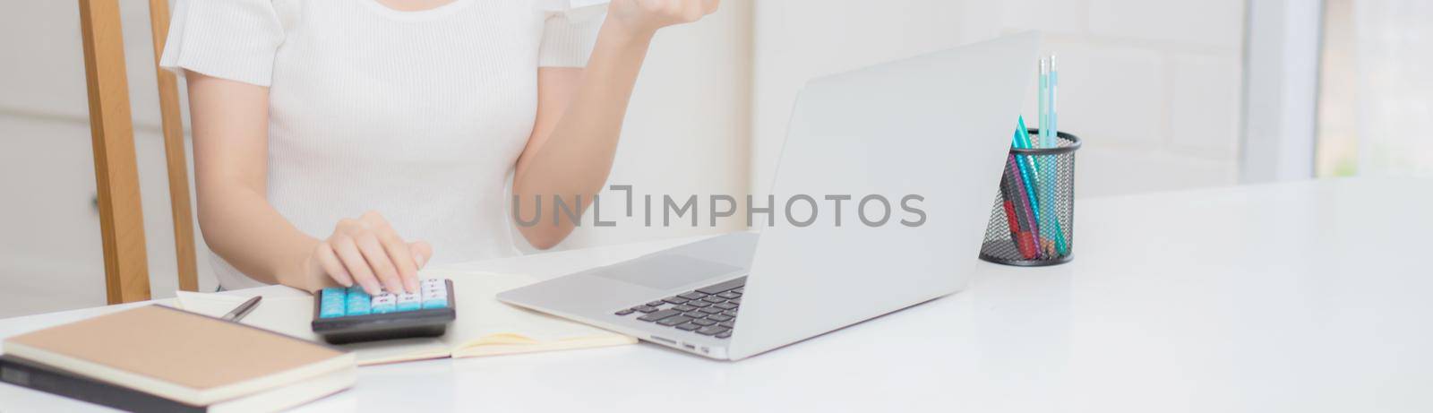 Young asian woman calculating finance household with calculator on desk at home, girl checking bill and success for saving expenses household, debt closure, tax and accounting, business concept.