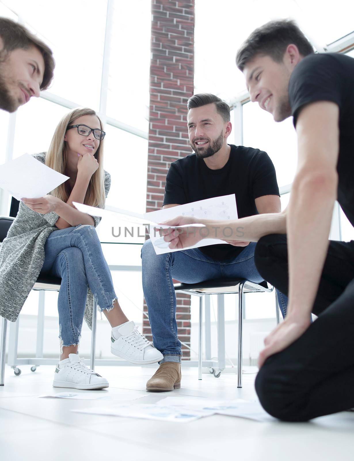 Business people sitting in office working with document having discussion.