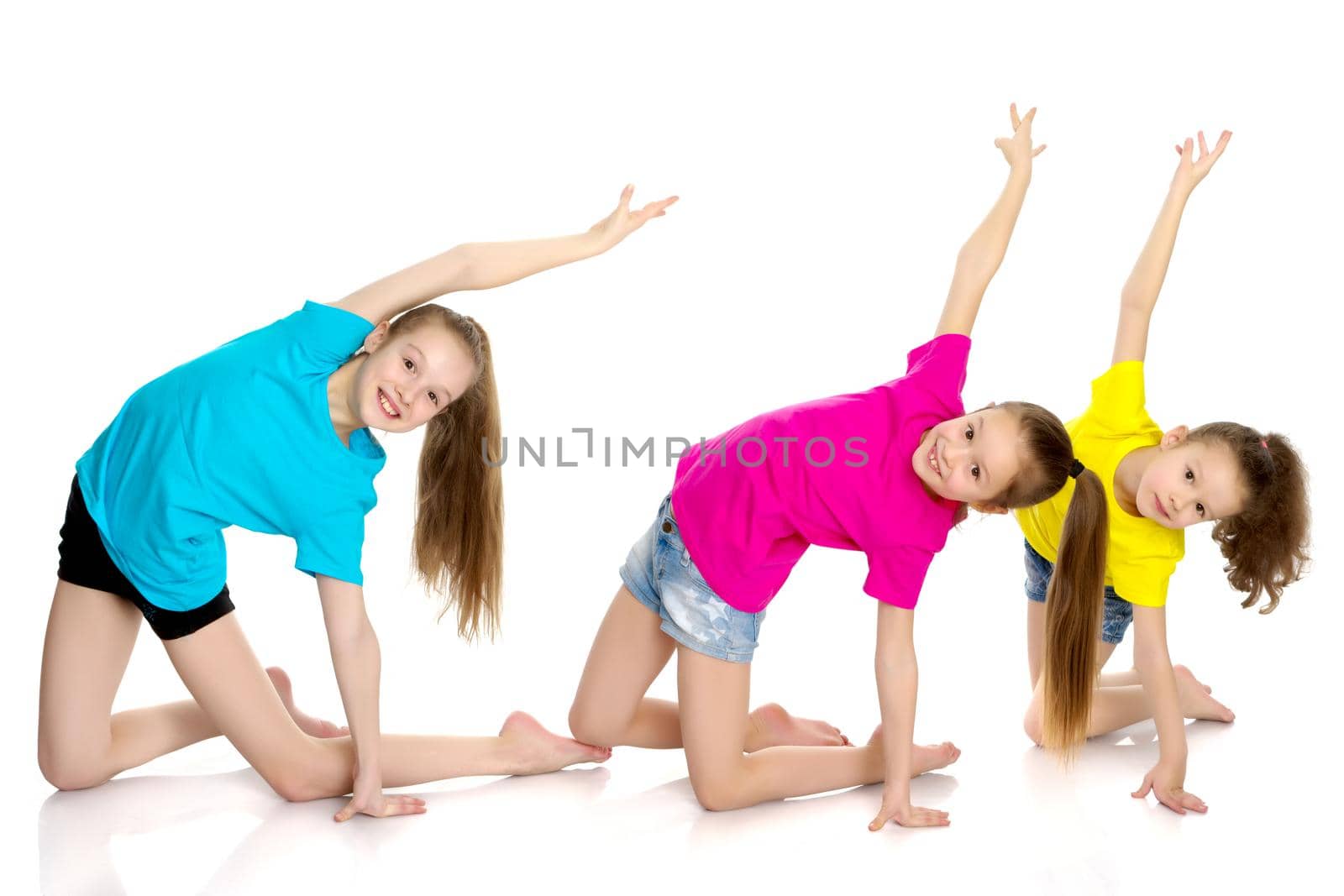A group of cheerful little girls-gymnasts performing various gymnastic and fitness exercises. The concept of an active way of life, a happy childhood. Isolated on white background.