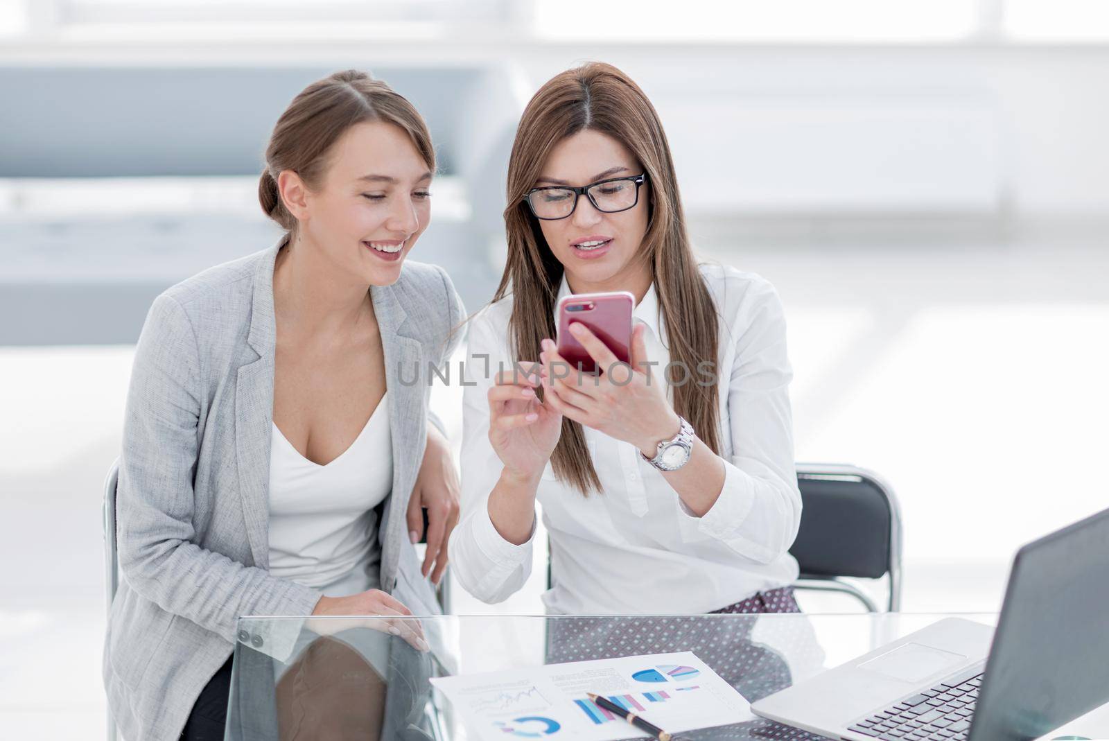 two business women looking at the smartphone screen by asdf