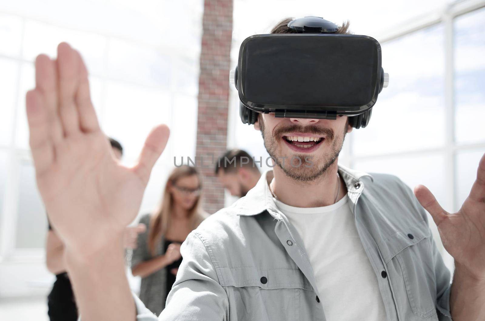 Inspiration. Cheerful young programmer smiling and pointing in front of herself while getting inspiration for her work in virtual reality