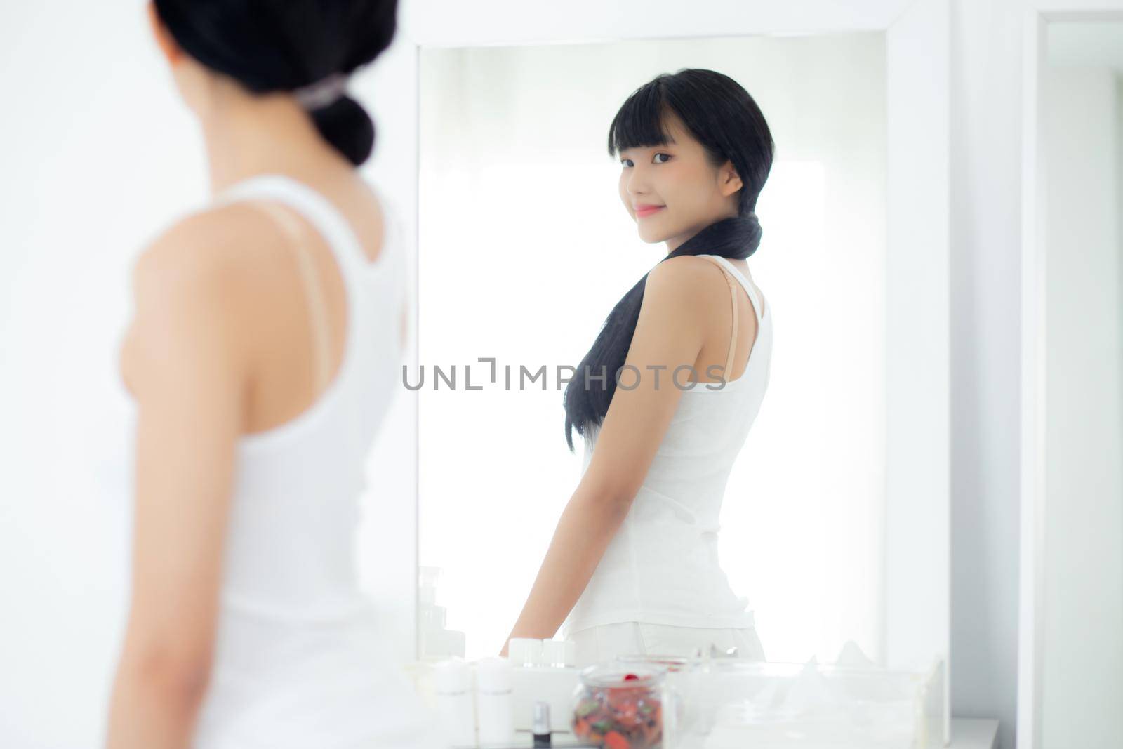 Beautiful young asian woman looking body in mirror with belly figure slim at home, beauty girl shape fit with weight loss, abdomen and waist sexy perfect, weightloss and diet, lifestyles concept.