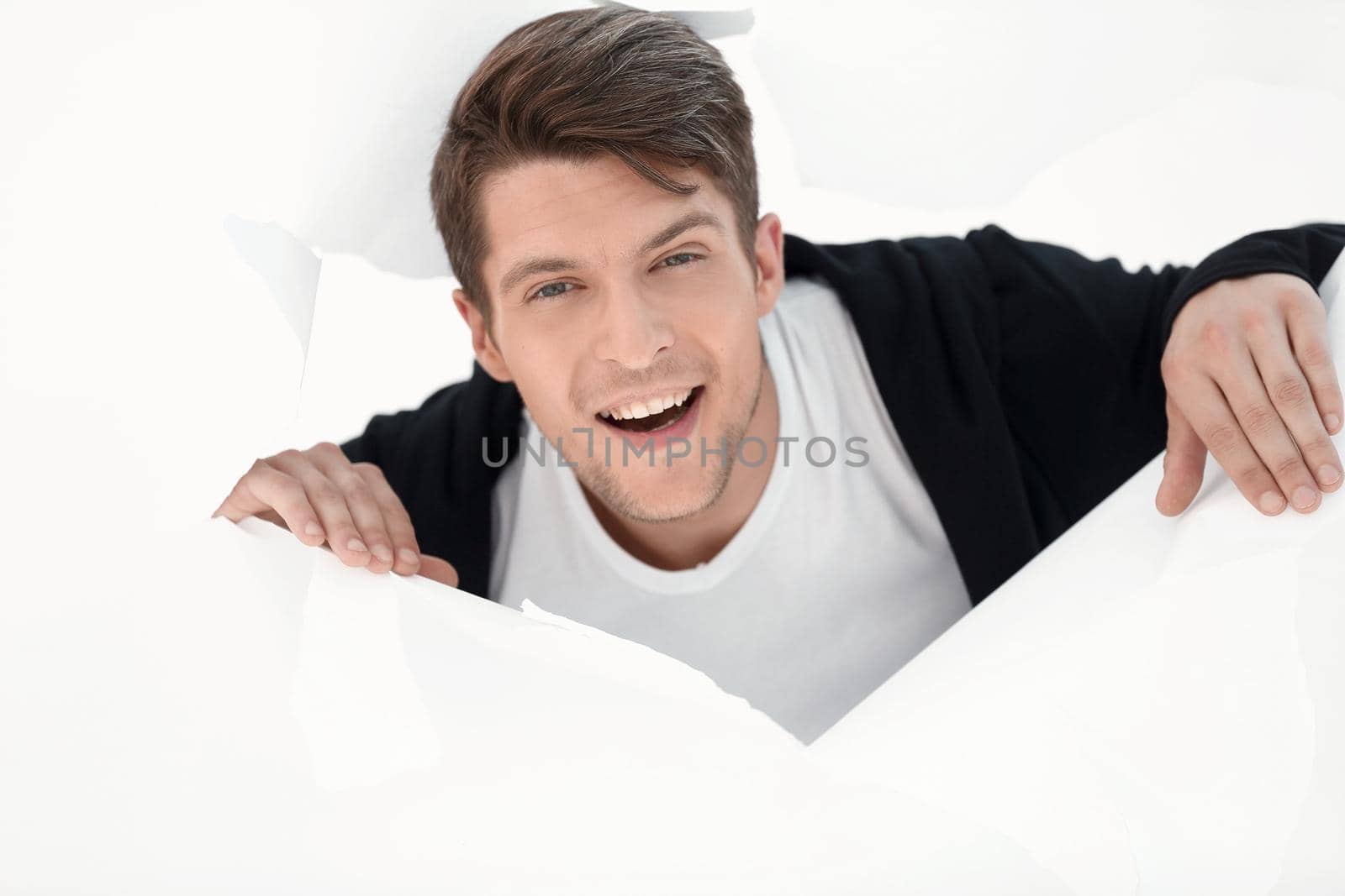 young businessman breaking through a paper wall.business concept