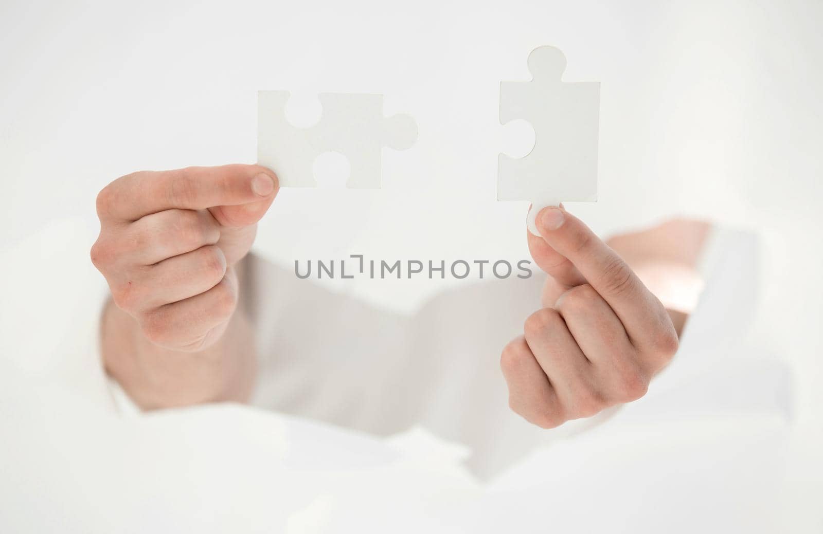 man connecting pieces of puzzles, breaking the wall of paper.photo with copy space