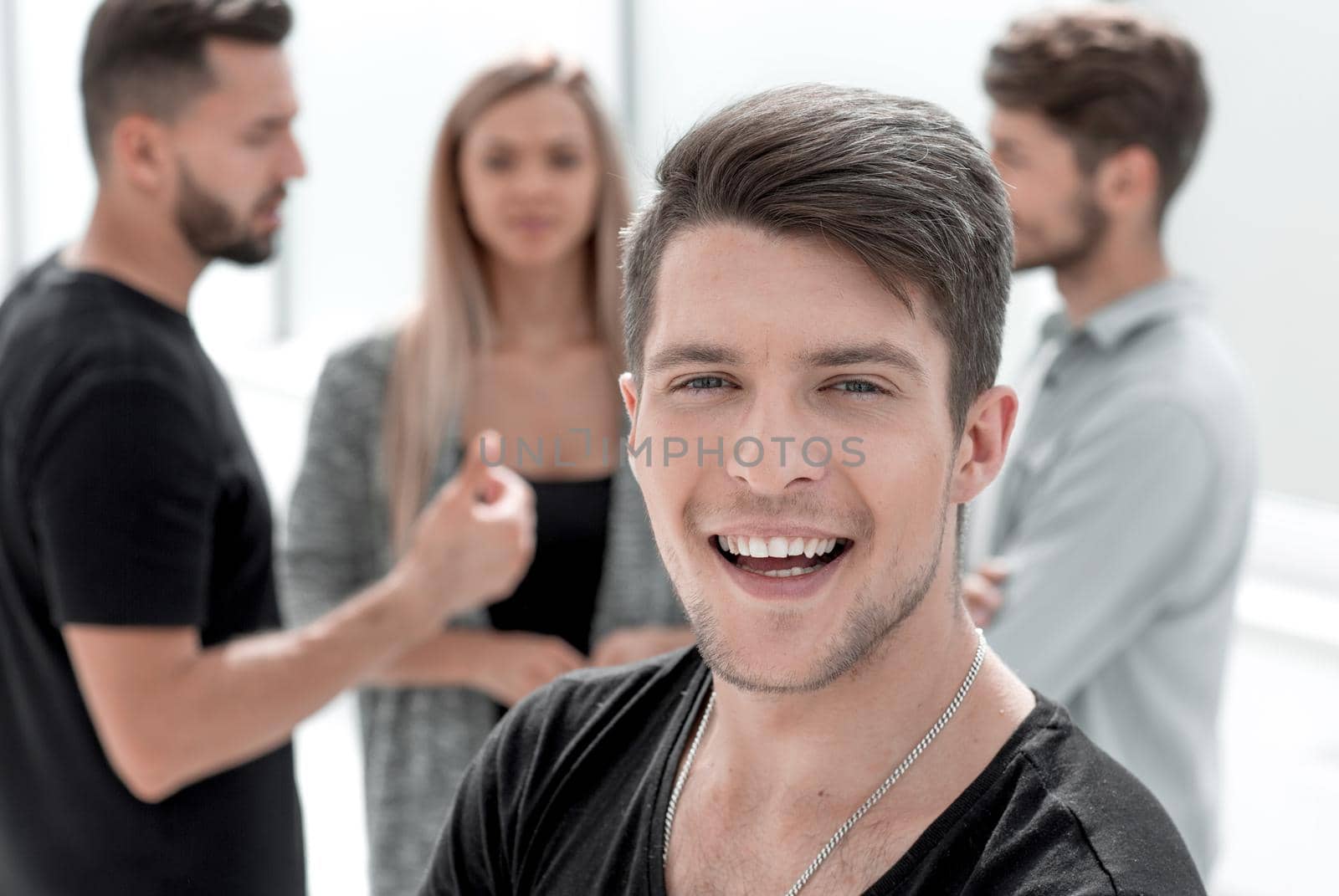 Studio shot of young man looking at the camera. Isolated on the office background. Horizontal format.