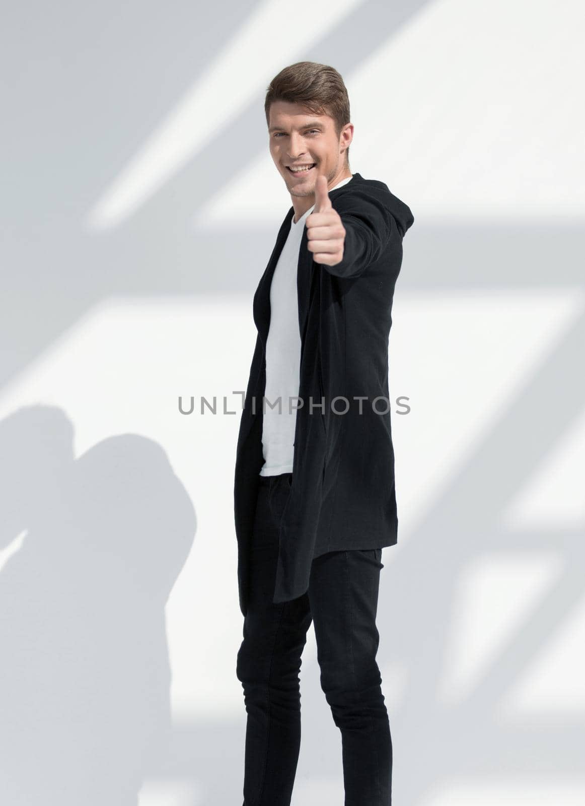 in full growth.smiling young man pointing at you.isolated on light background