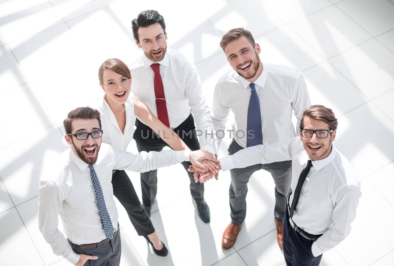 top view. young employees folding their hands together. photo with copy space