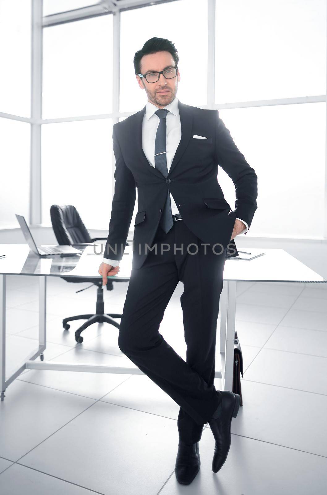 Confident in the future. confident businessman standing near his Desk.in full growth