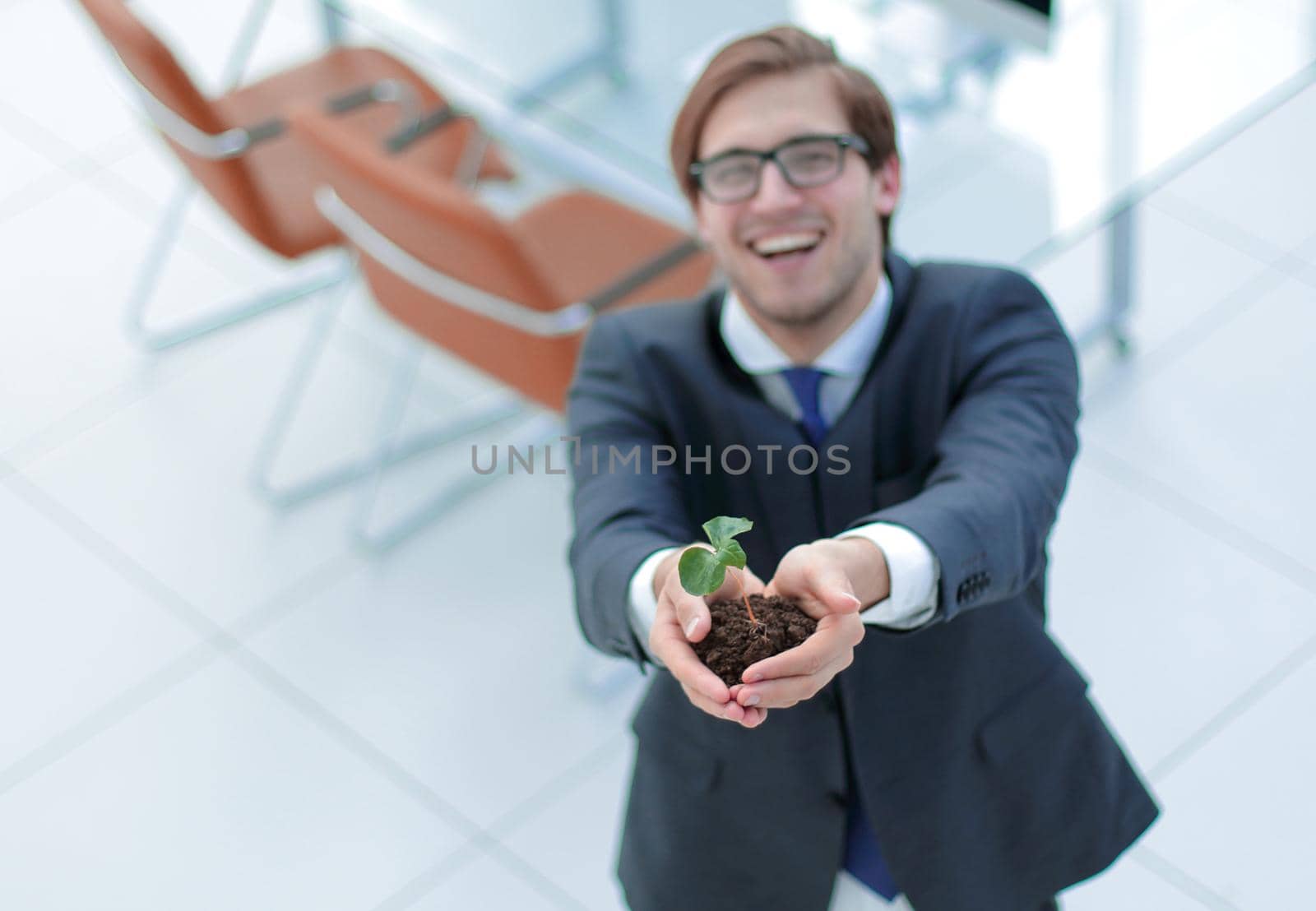 top view.young businessman showing green sprout