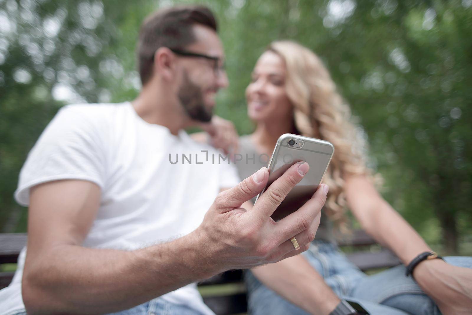 young couple sitting on a bench and using smartphone.people and technology
