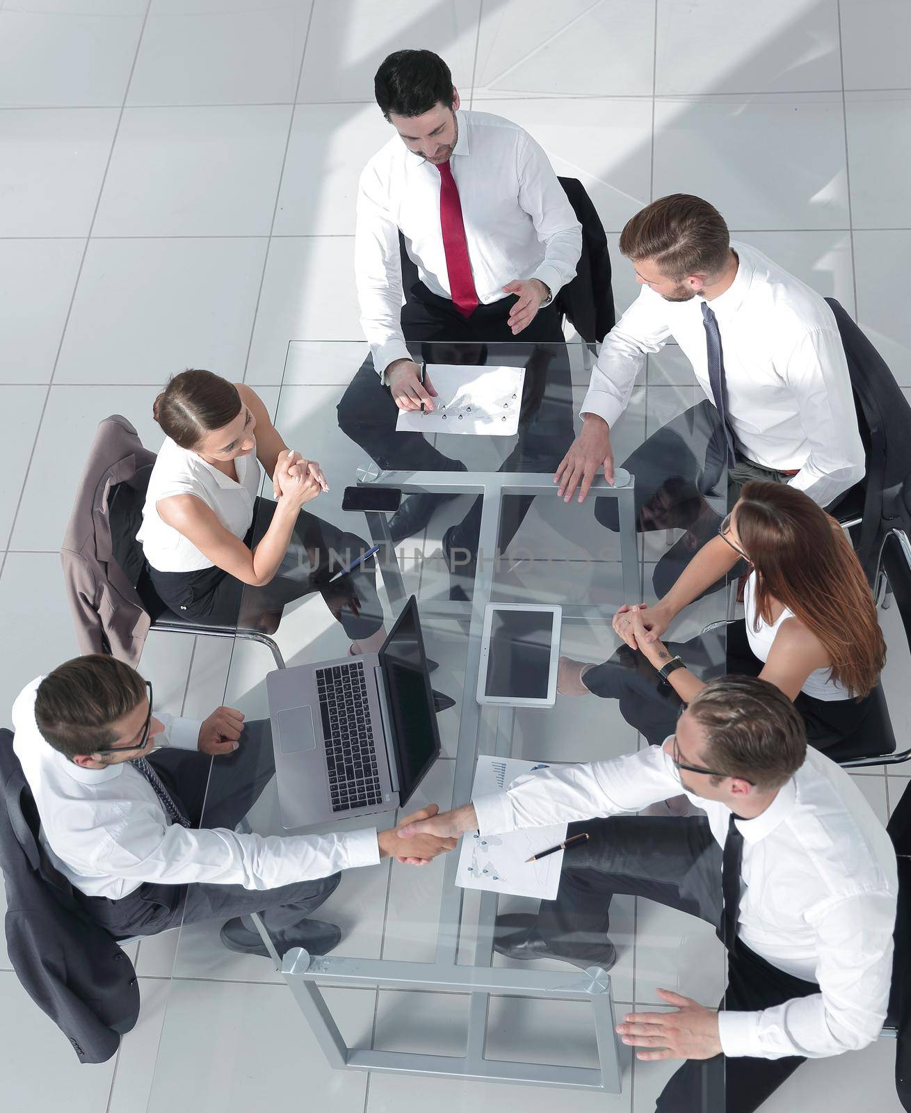 Office workers gather around a table to do research and implement new ideas.