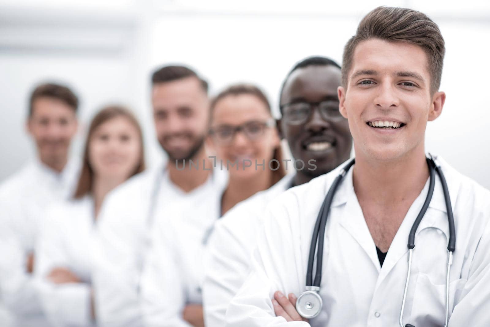 Team of young professional doctors standing together in laboratory, posing with arms crossed