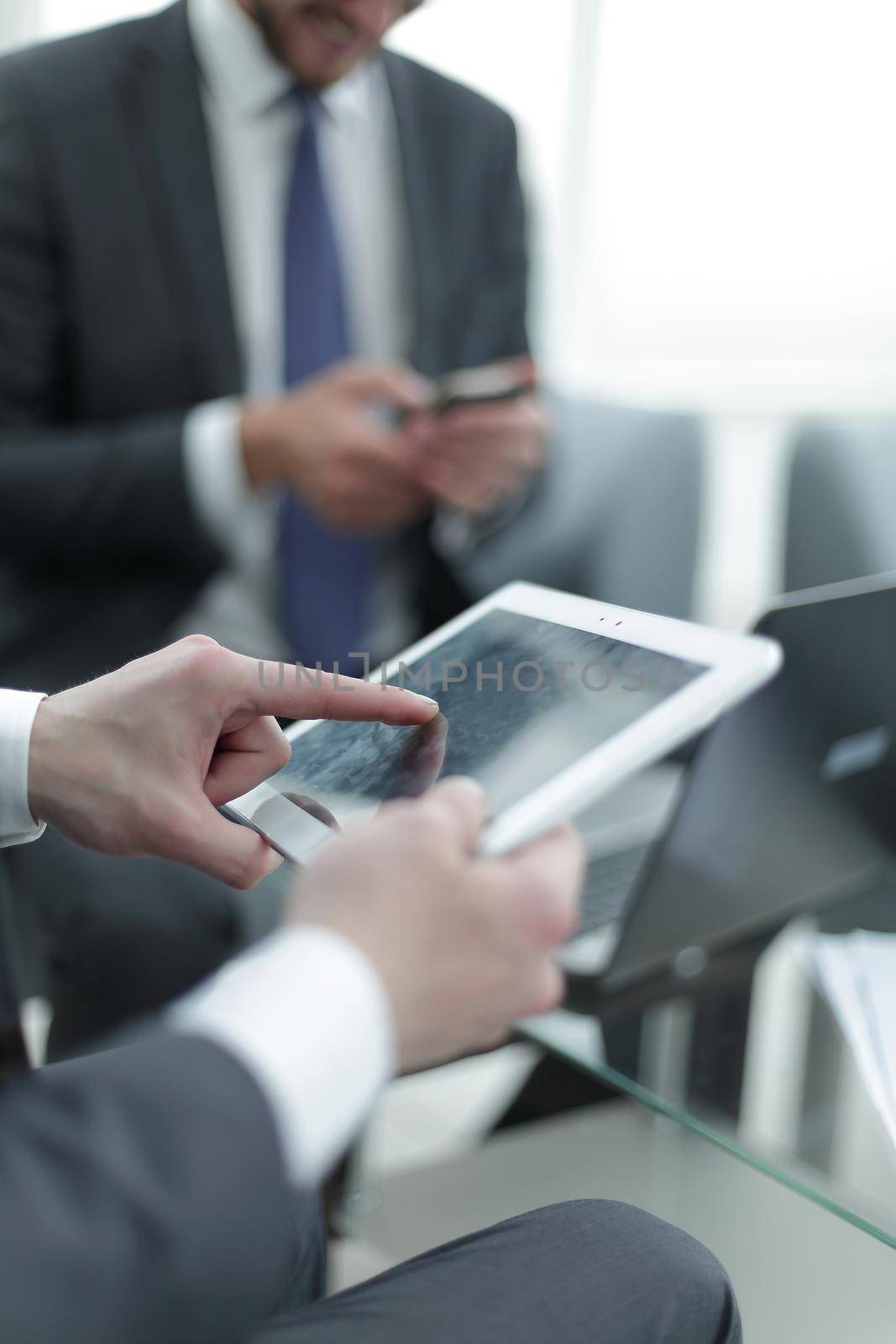 close up.the businessman uses a digital tablet in the workplace . new technology concept