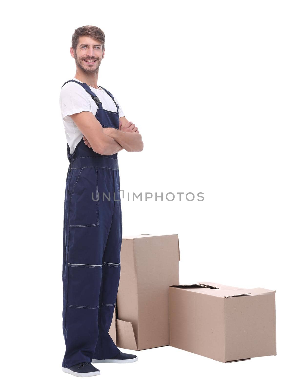 in full growth. man courier standing near cardboard boxes.isolated on white background