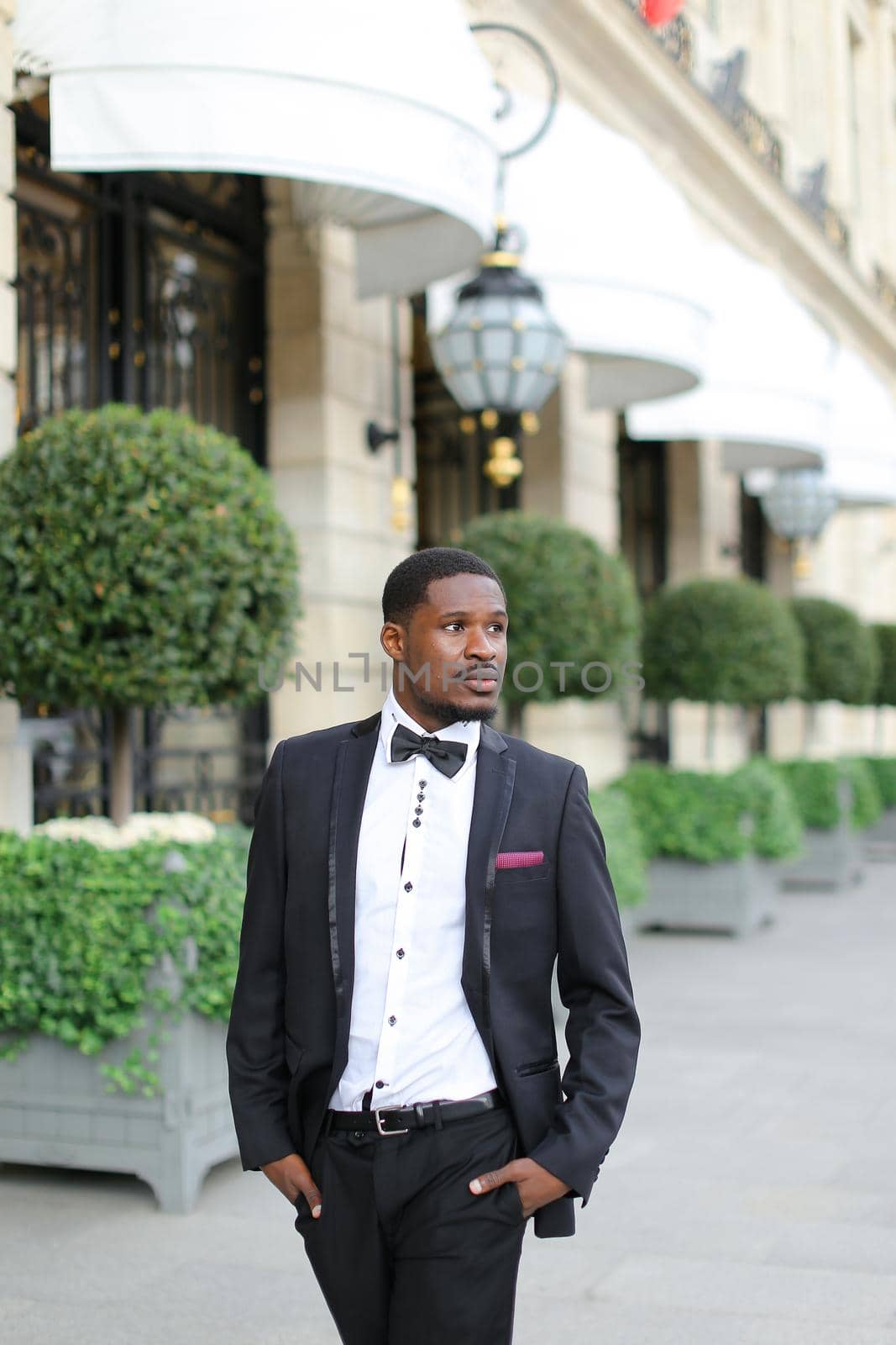 Afro handsome american man wearing suit and standing near building. by sisterspro