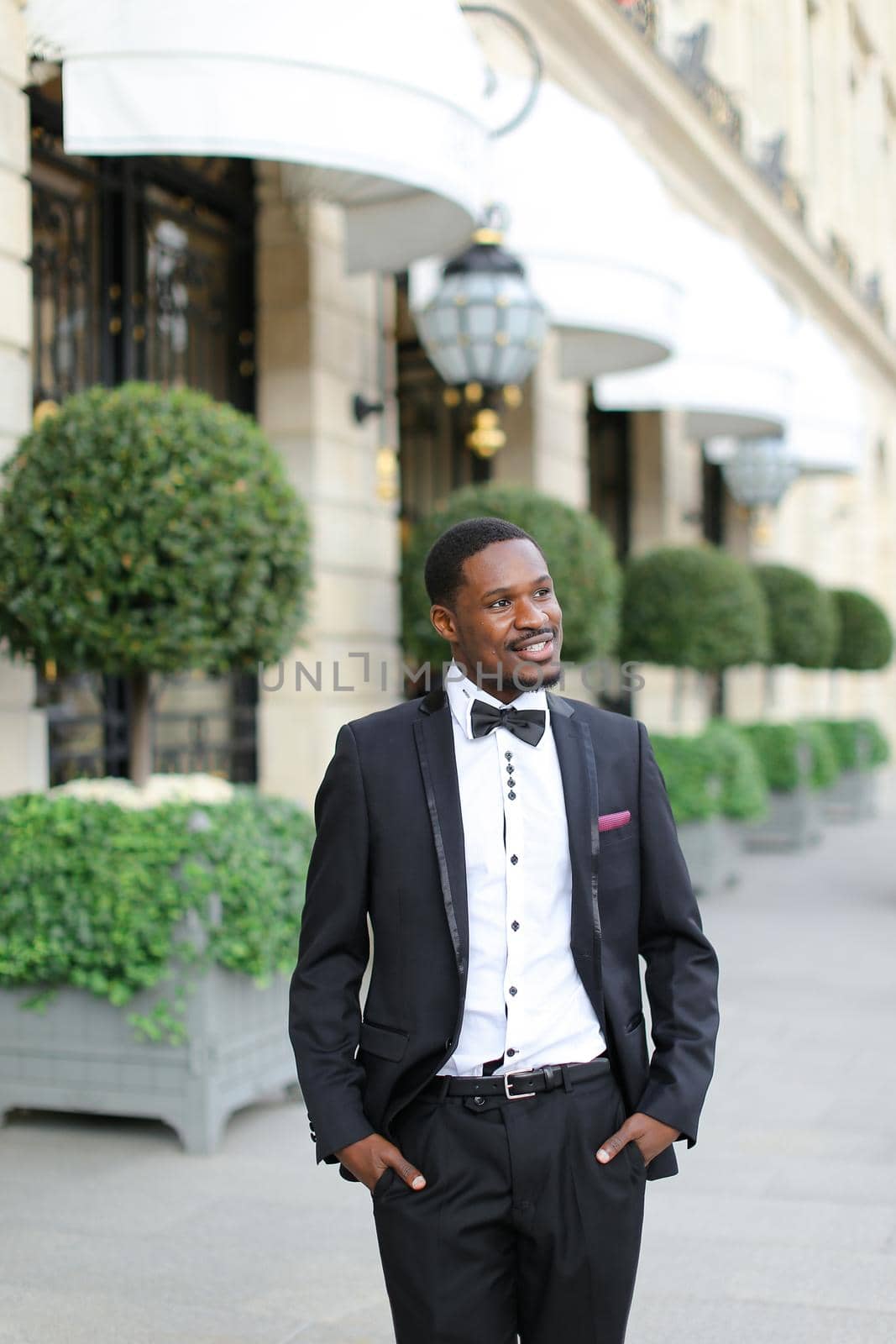 Afro american happy man wearing suit and standing outside. Concept of black businessman.