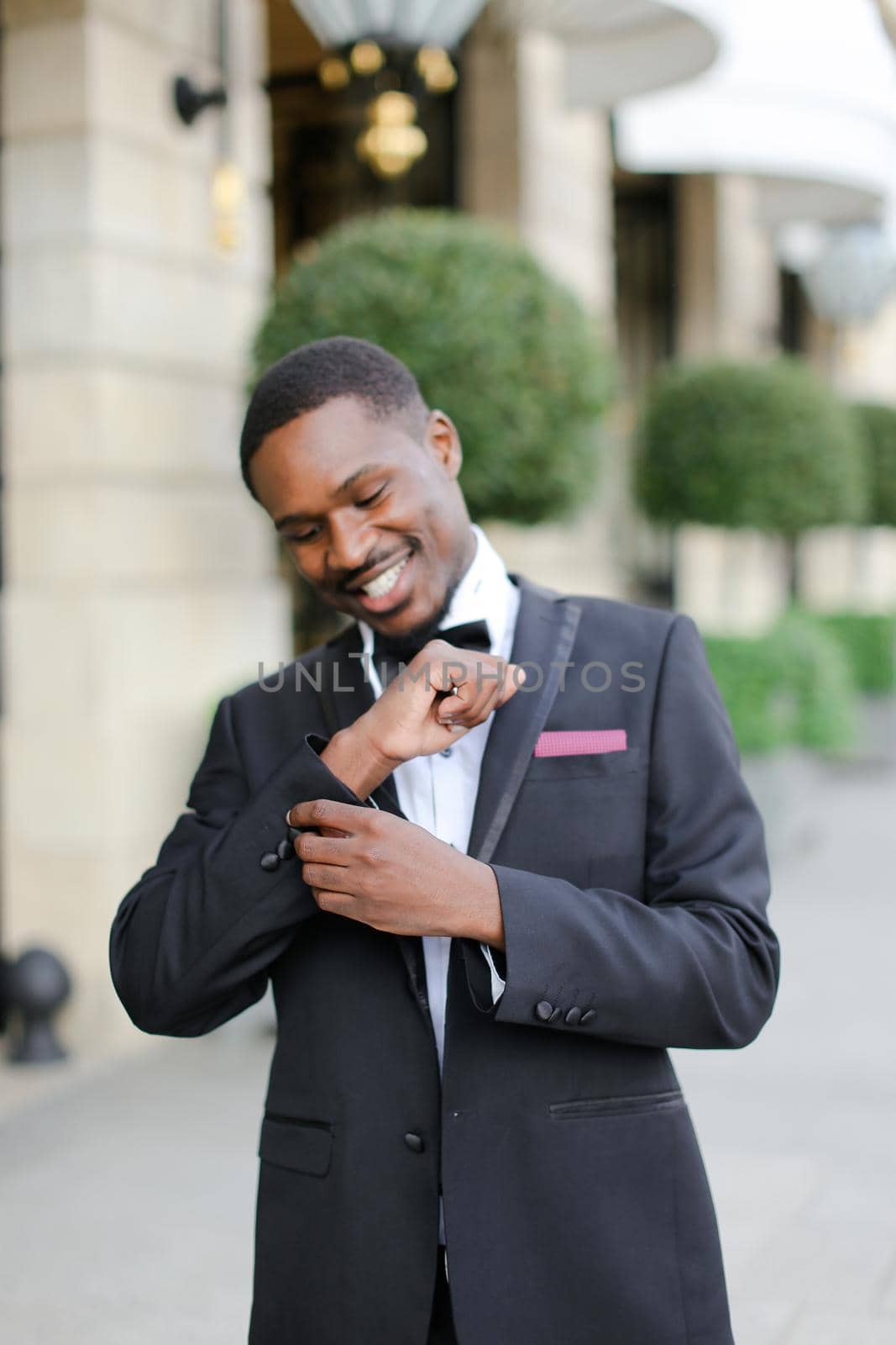 Afro american man wearing suit and waiting for meeting near building. by sisterspro