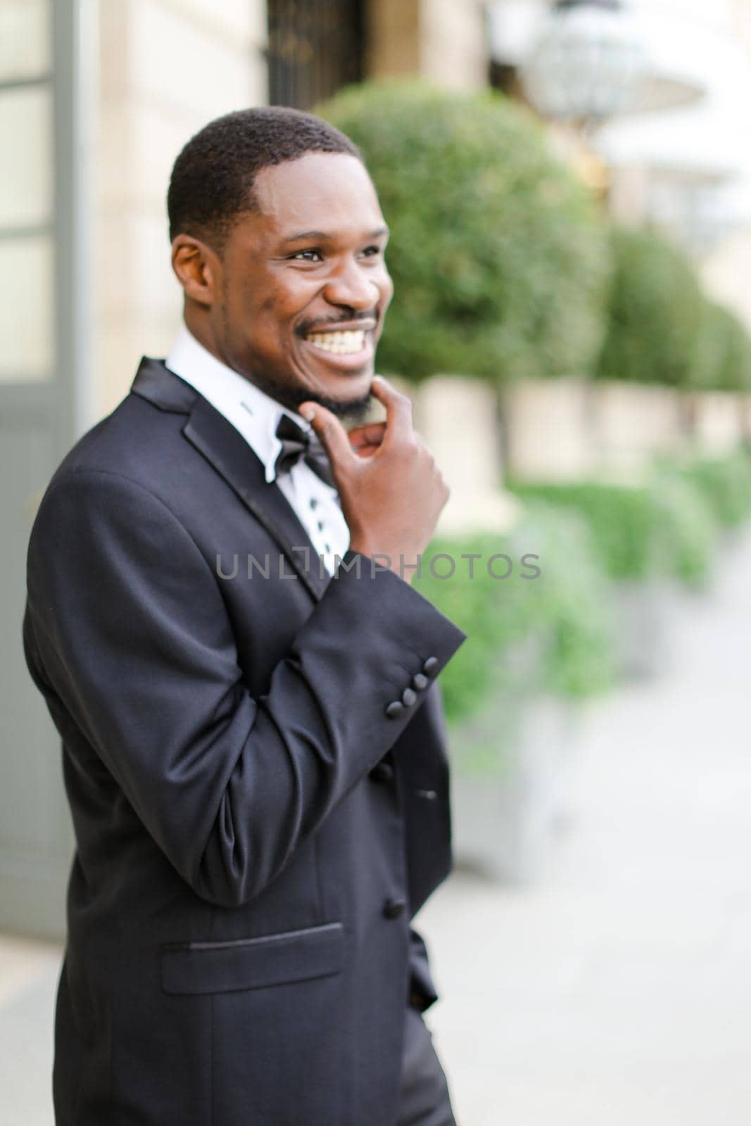 Afro american happy good looking male person wearing suit and smiling. Concept of black businessman.