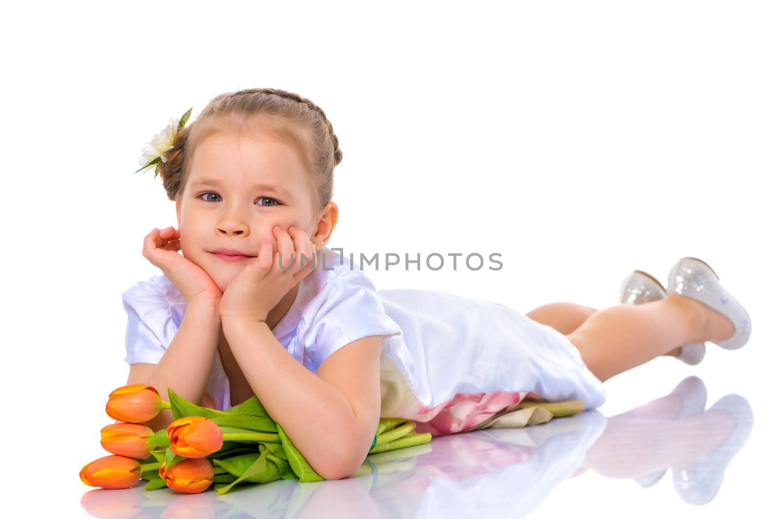 A little girl is lying on the floor with a bouquet of tulips. by kolesnikov_studio