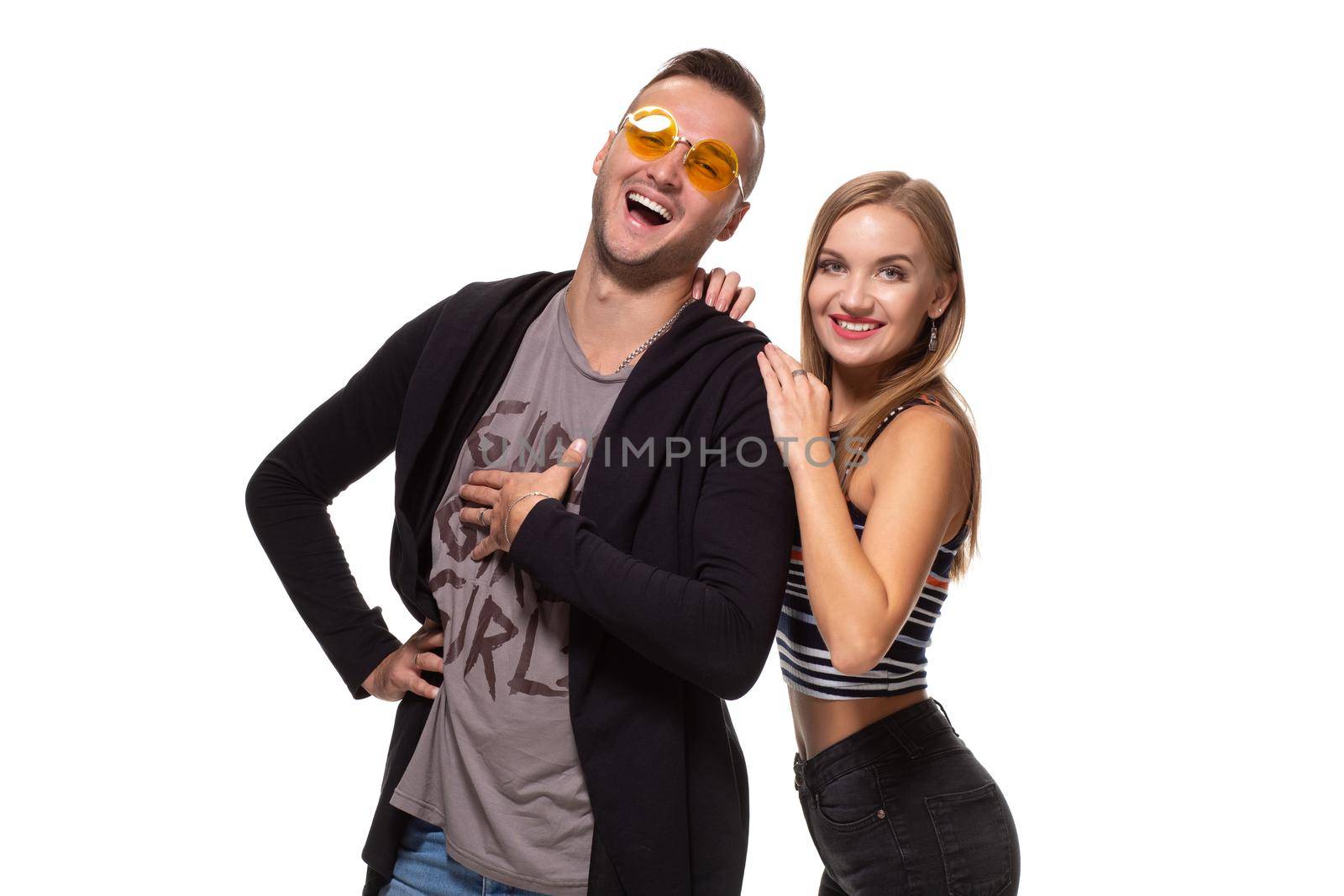 Happy young lovely couple standing together and laughing. Studio shot over white background. by nazarovsergey