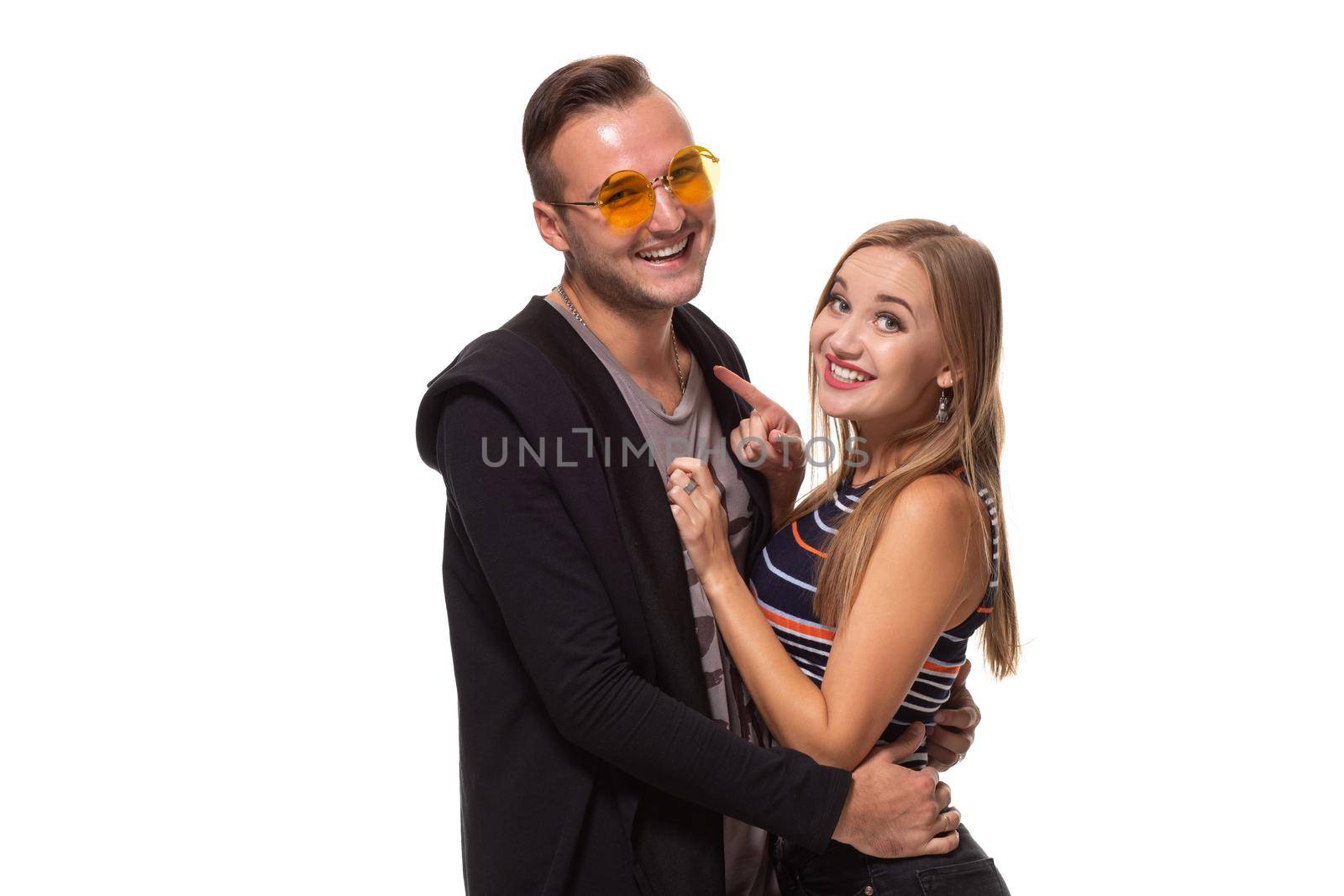 Happy young lovely couple standing together and laughing. Studio shot over white background. by nazarovsergey