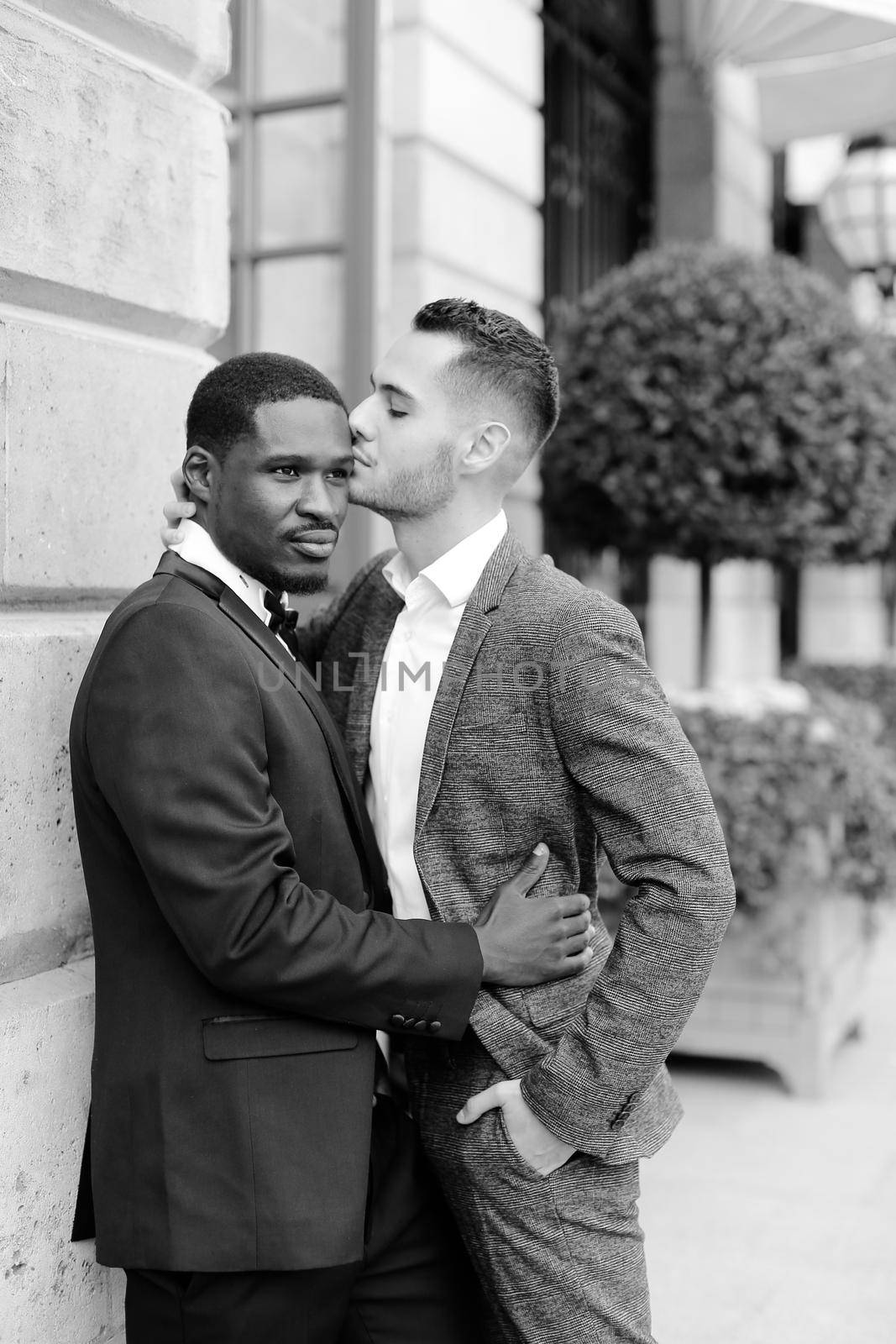 Black and white photo afro american gay hugging european man outdoors. Concept of lgbt and same sex couple.